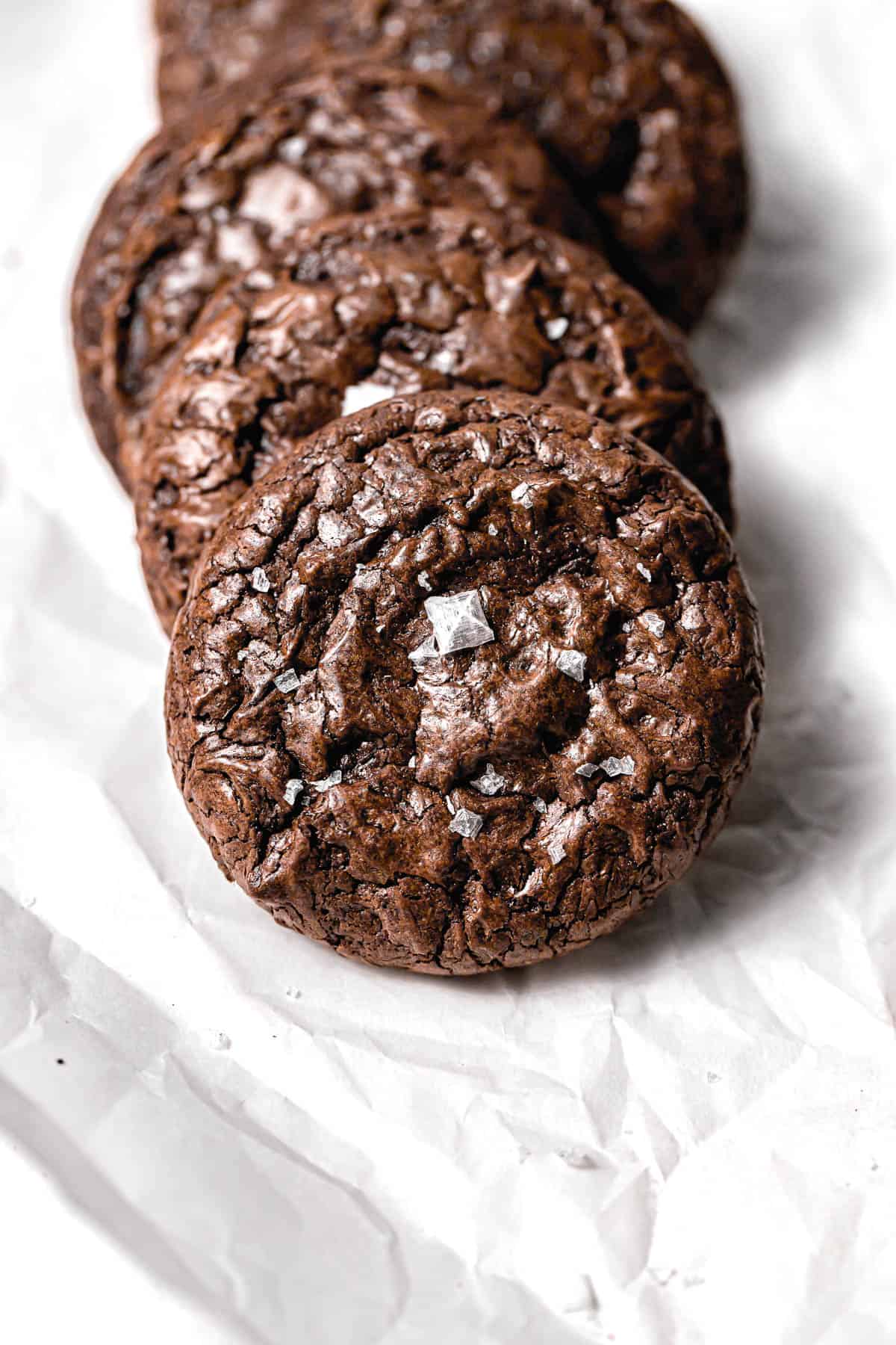 brownie cookies lined up on parchment paper.