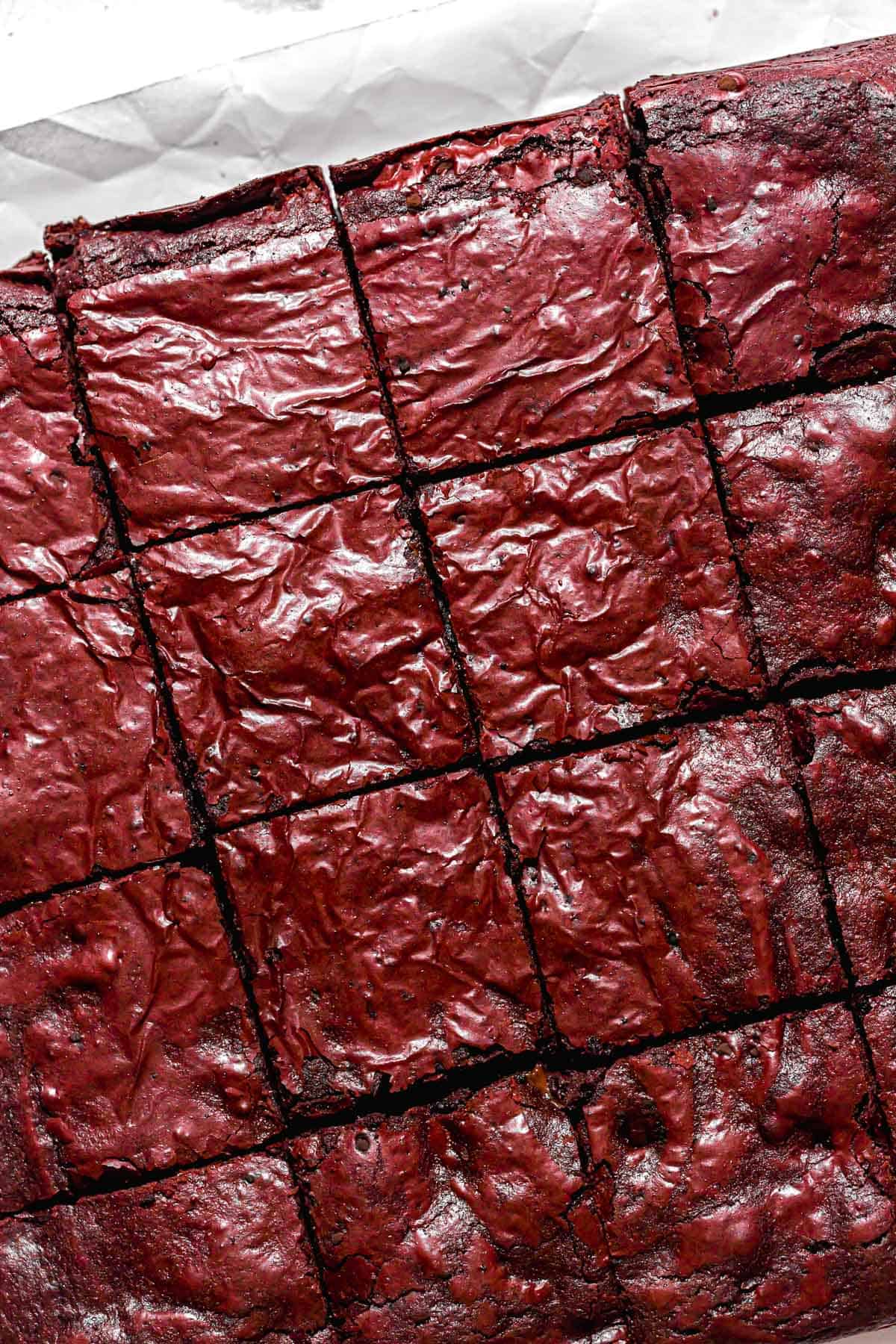 baked brownies cut into squares on parchment paper