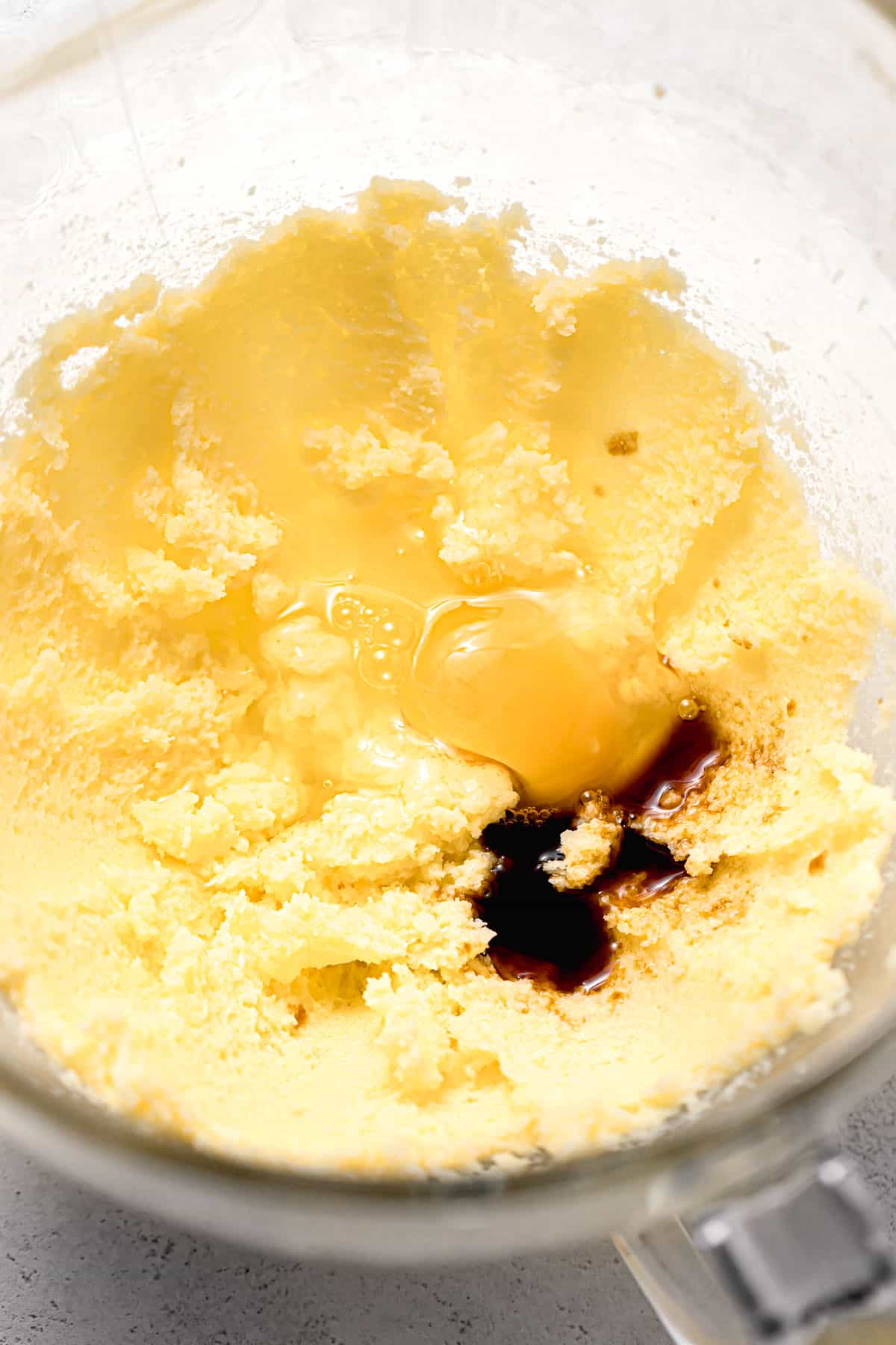 egg and vanilla added to butter sugar mixture in glass bowl.