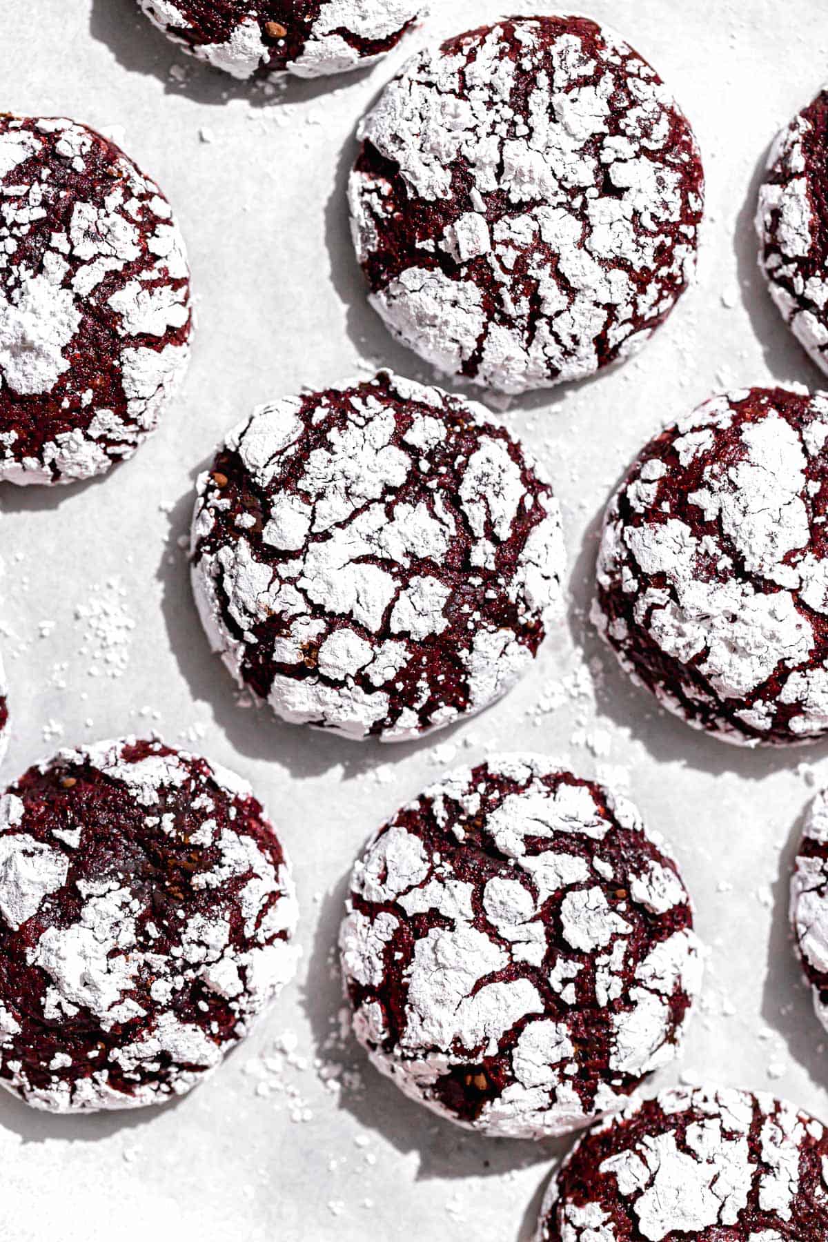 red velvet crinkle cookies on parchment paper.