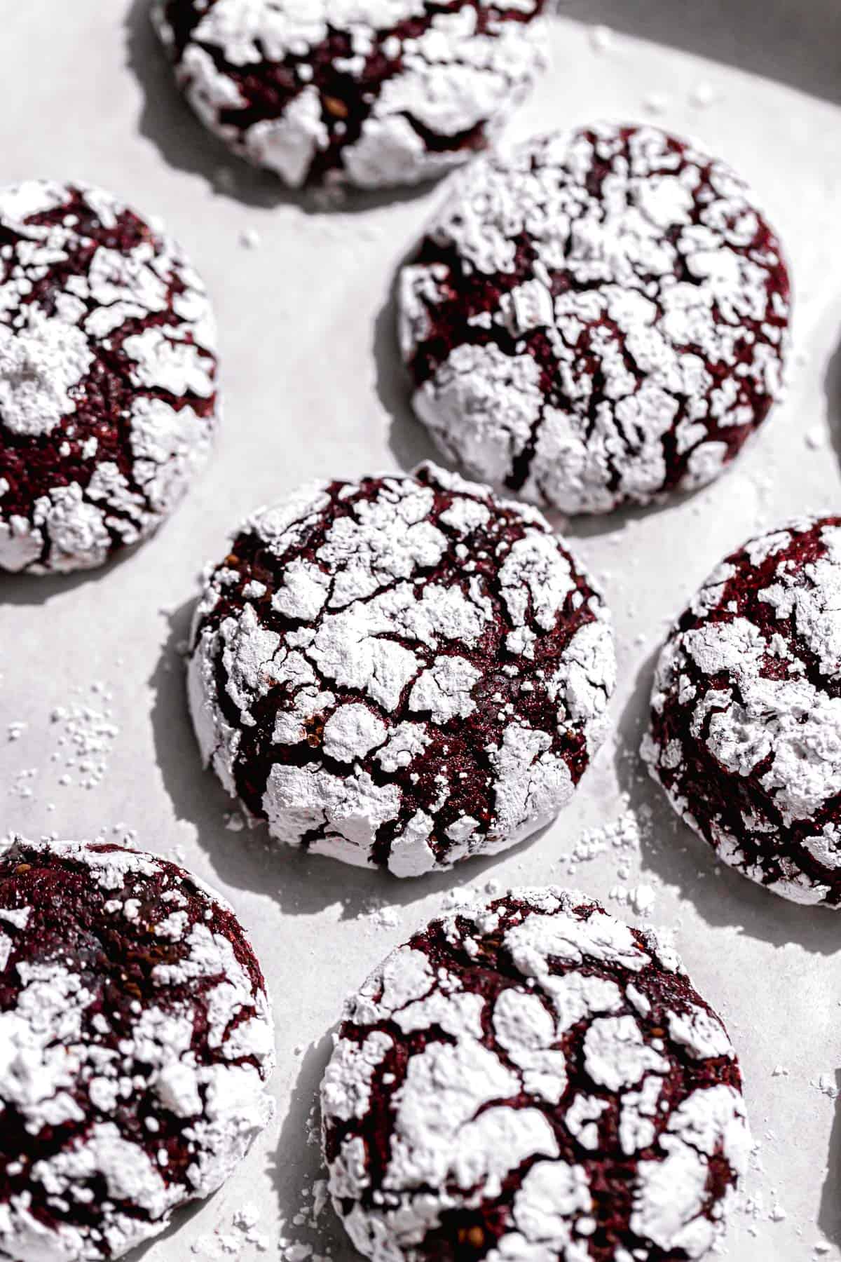 red velvet crinkle cookies on parchment lined baking sheet.