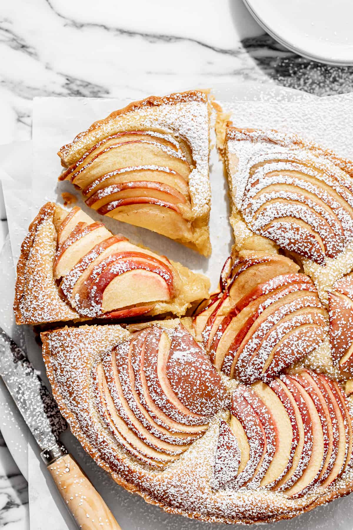 apple frangipane tart with two pieces cut.