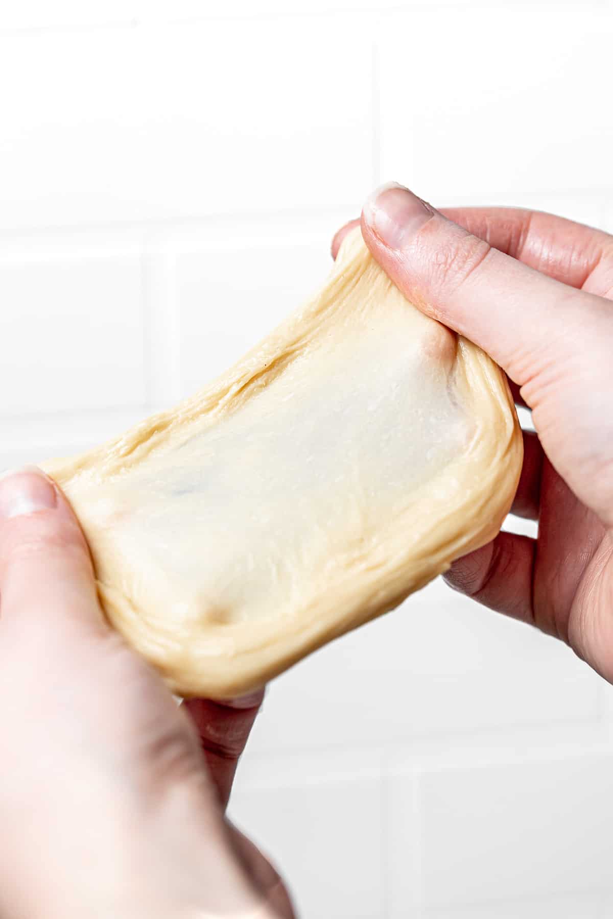 piece of dough stretched out with two hands. 