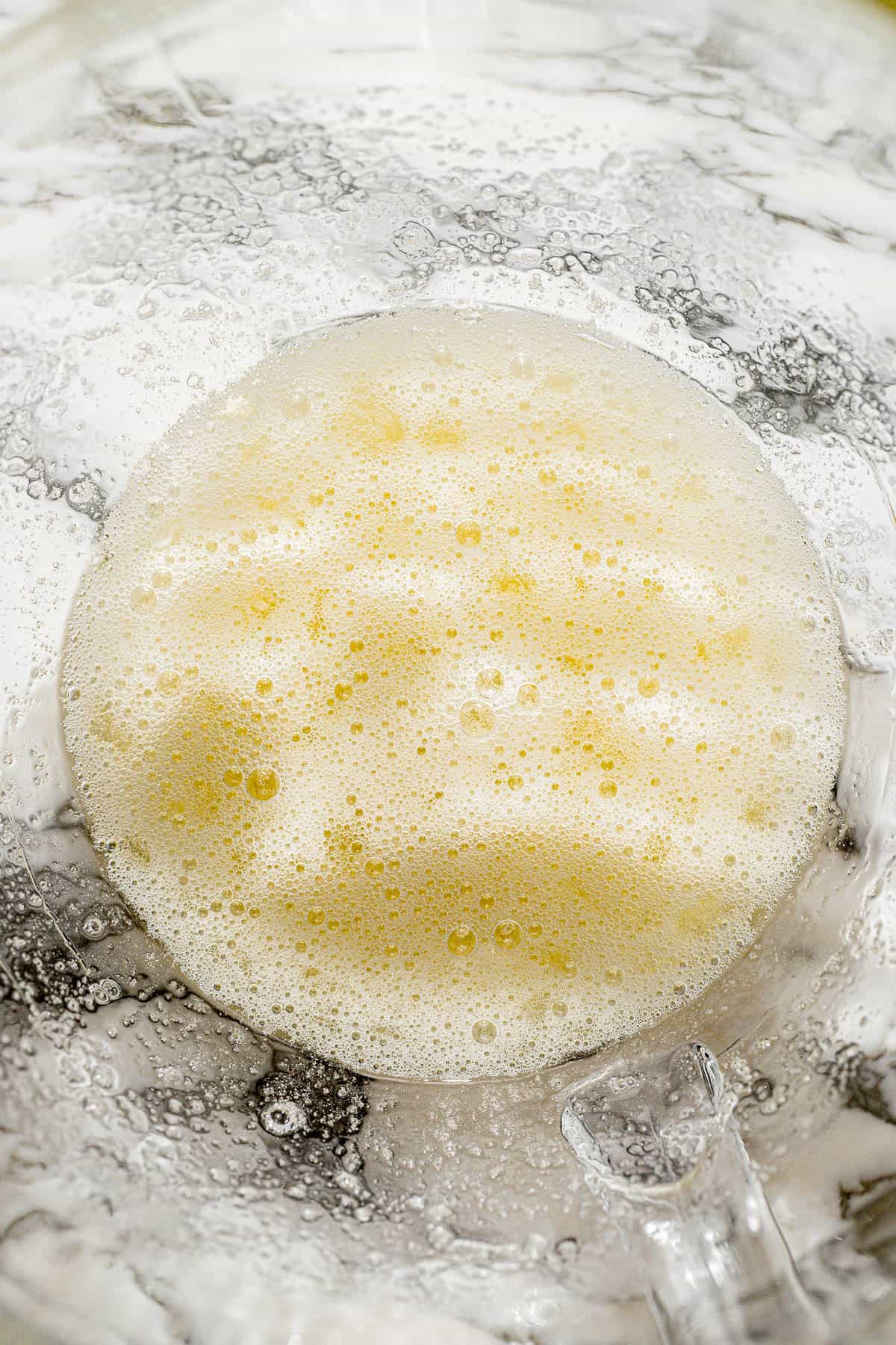 egg whites and sugar mixed in glass mixing bowl.