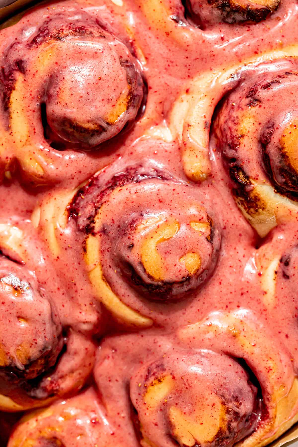 baked cinnamon rolls topped with icing. 
