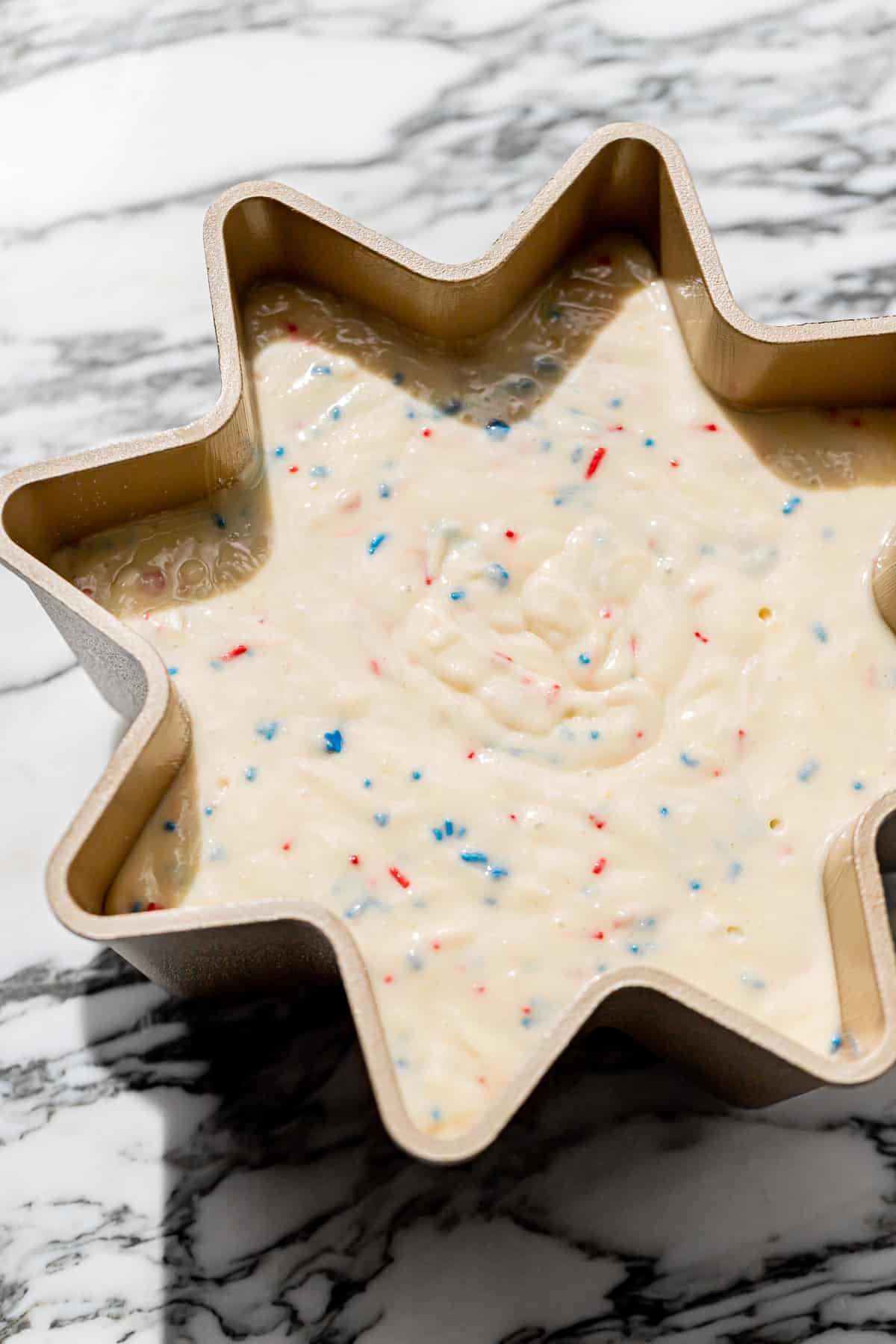 funfetti cake batter added to fluted pan.