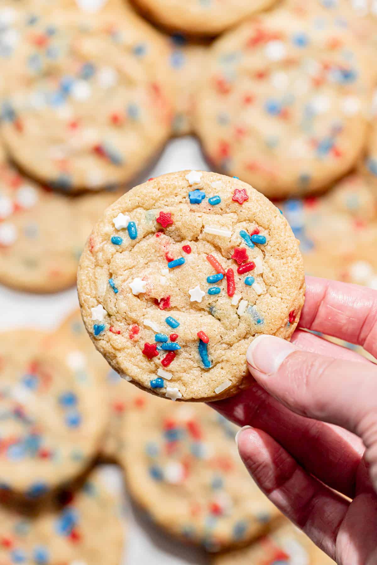 one 4th of July cookie held in one hand.