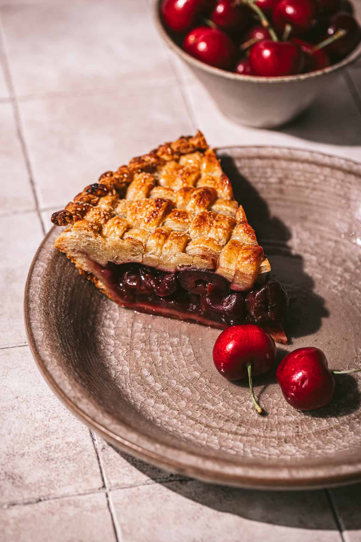 one piece of cardamom cherry pie with frozen cherries on plate. 