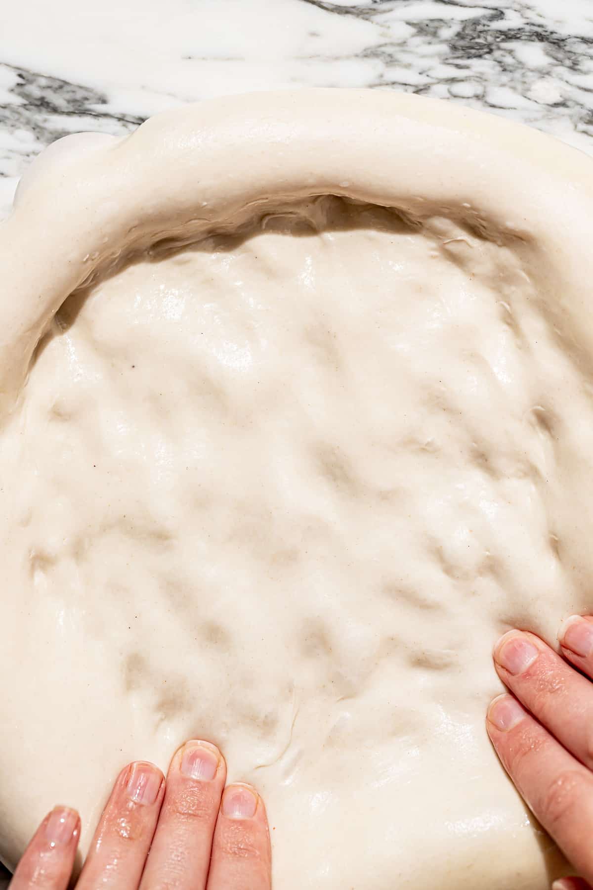 overnight pizza dough being stretched out. 