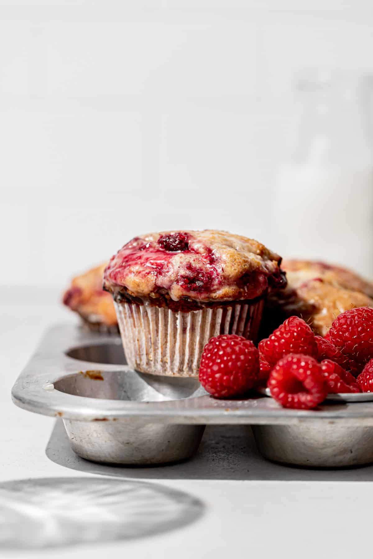 baked lemon raspberry muffin on top of muffin pan.