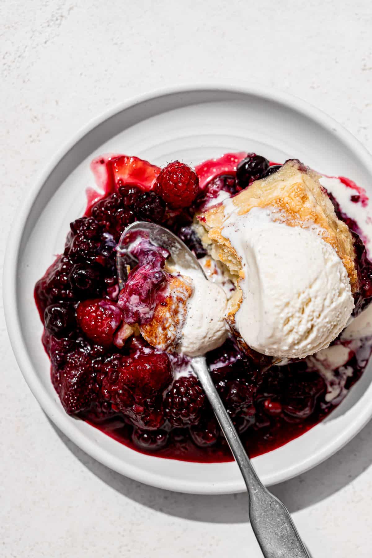 mixed berry cobbler on white plate. 