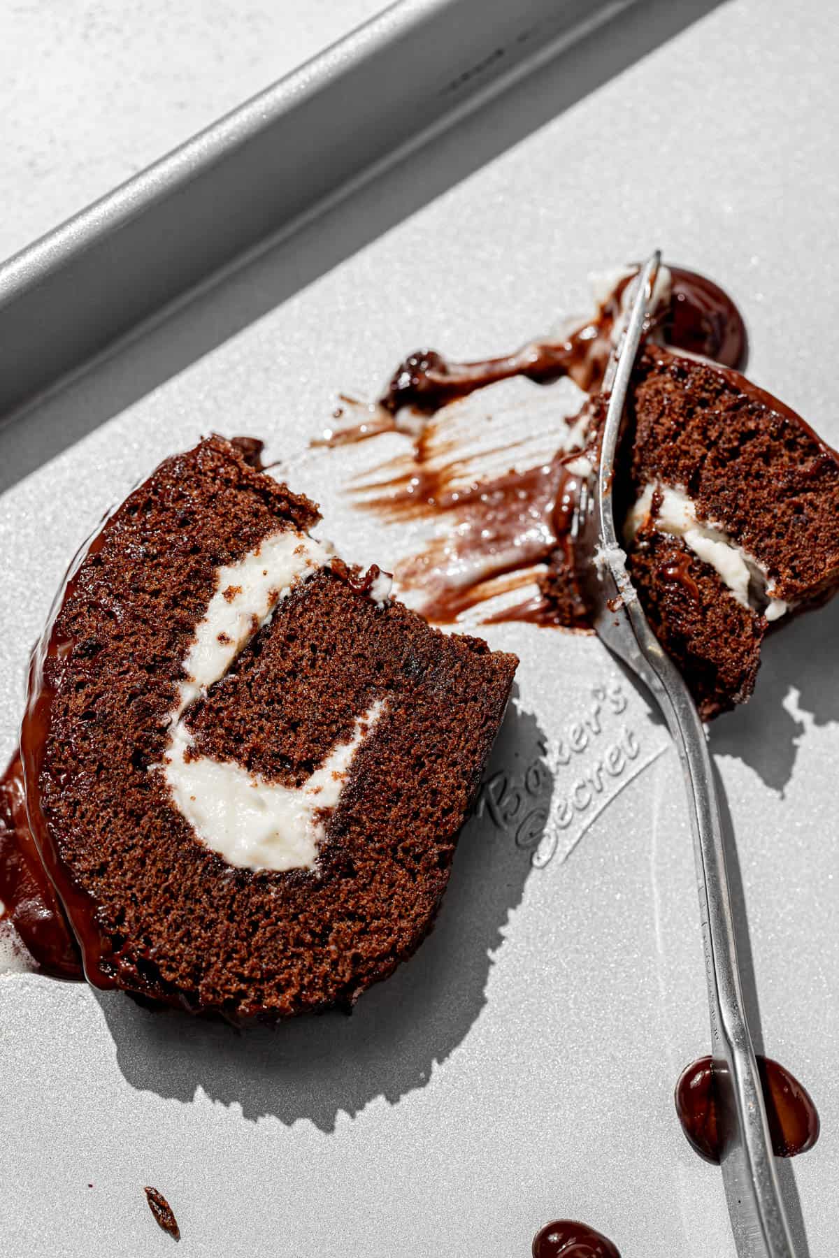 chocolate swiss roll cake slice on baking sheet.