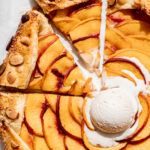 almond peach galette with a scoop of vanilla ice cream on top.