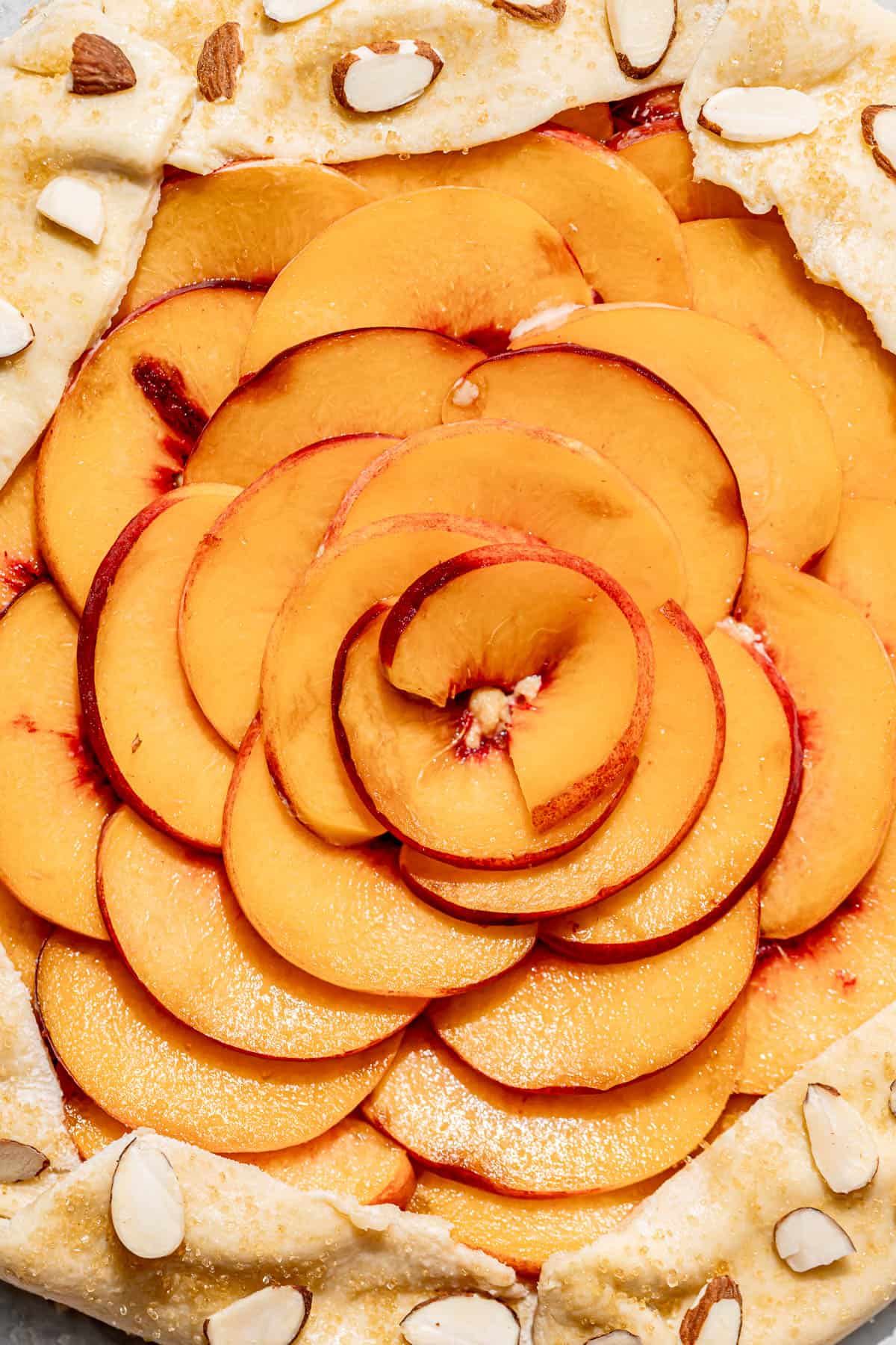 close up of peaches arranged in a circle on top of prepared galette crust.
