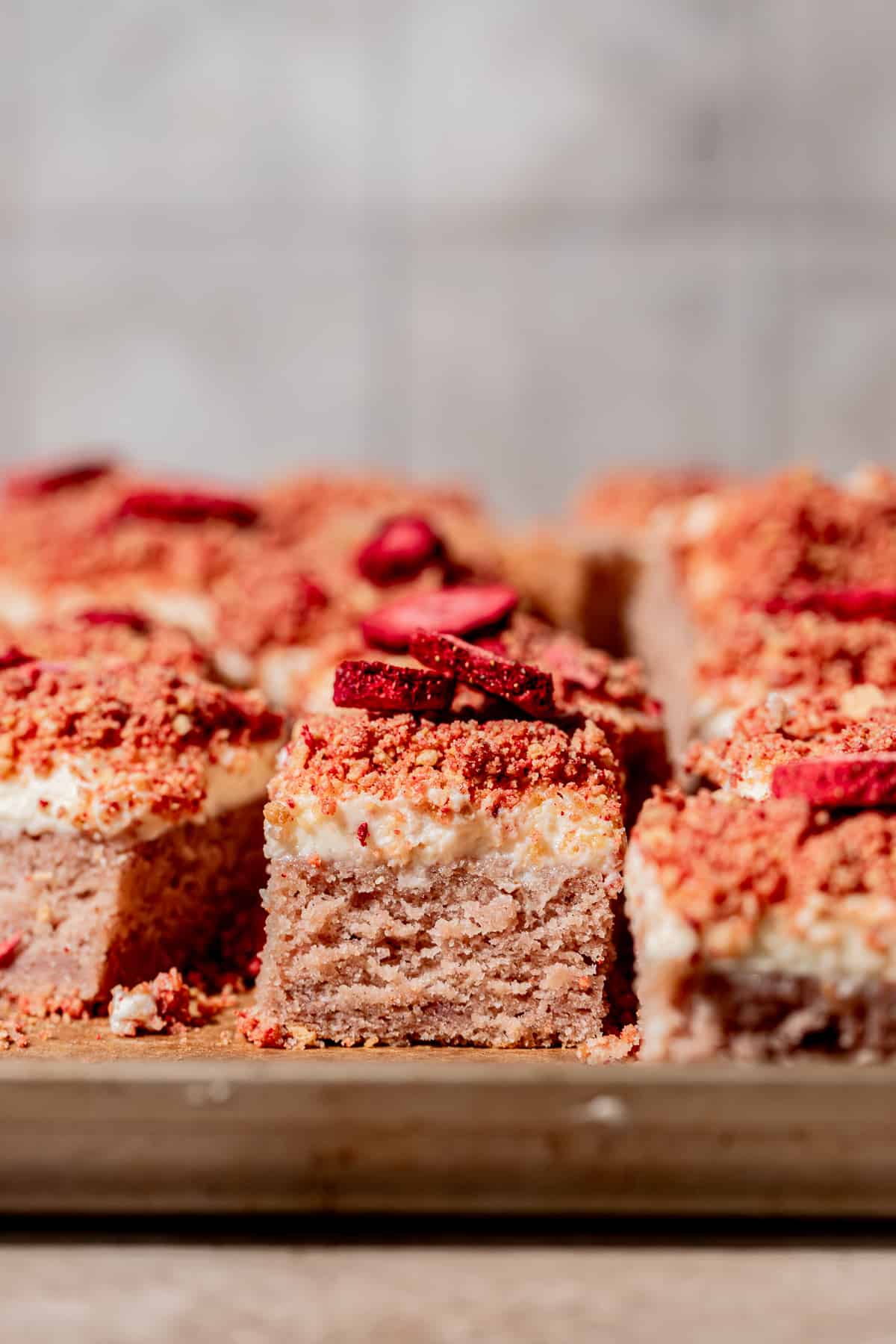 head-on view of strawberry crunch cake cut into squares.