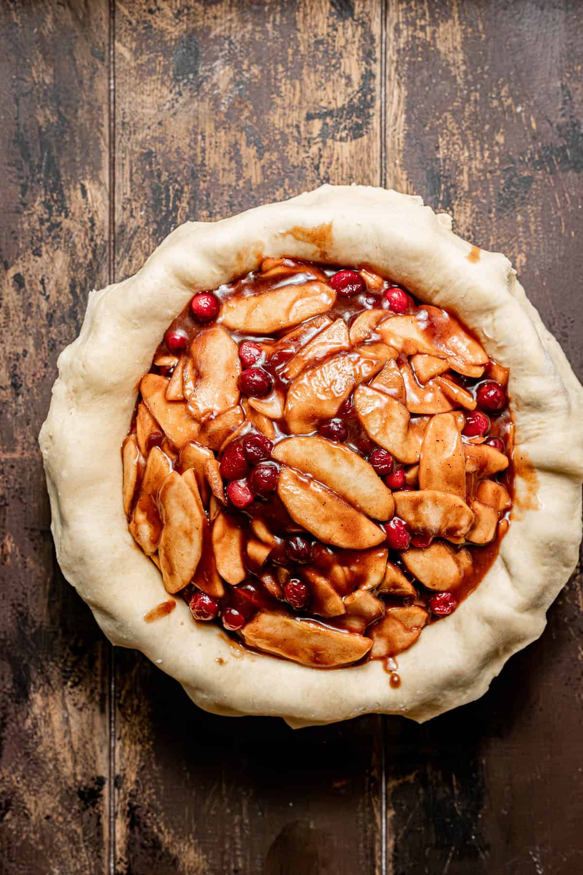 filled apple cranberry pie without lattice crust on top.