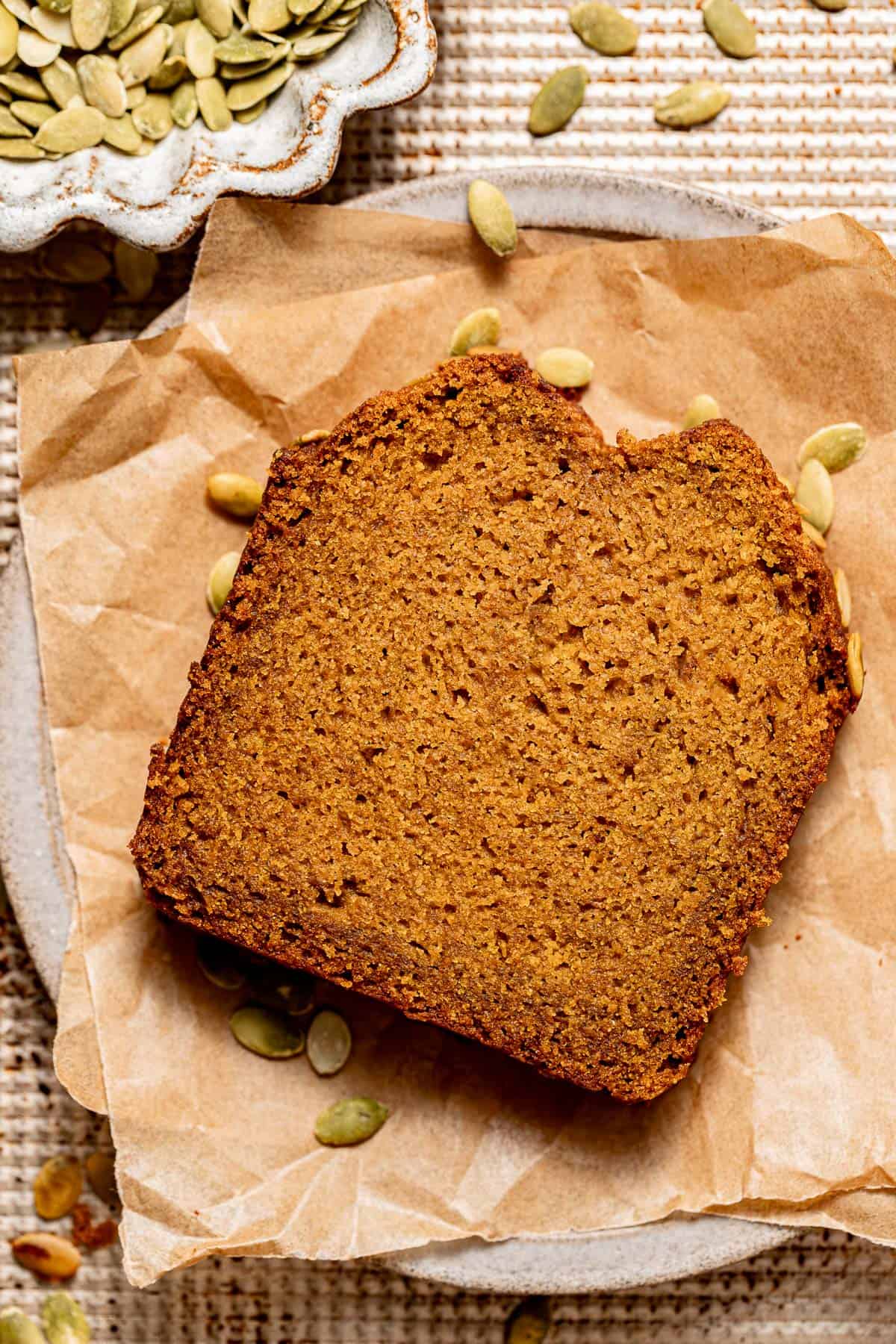slice of pumpkin bread on a plate with parchment paper underneath.