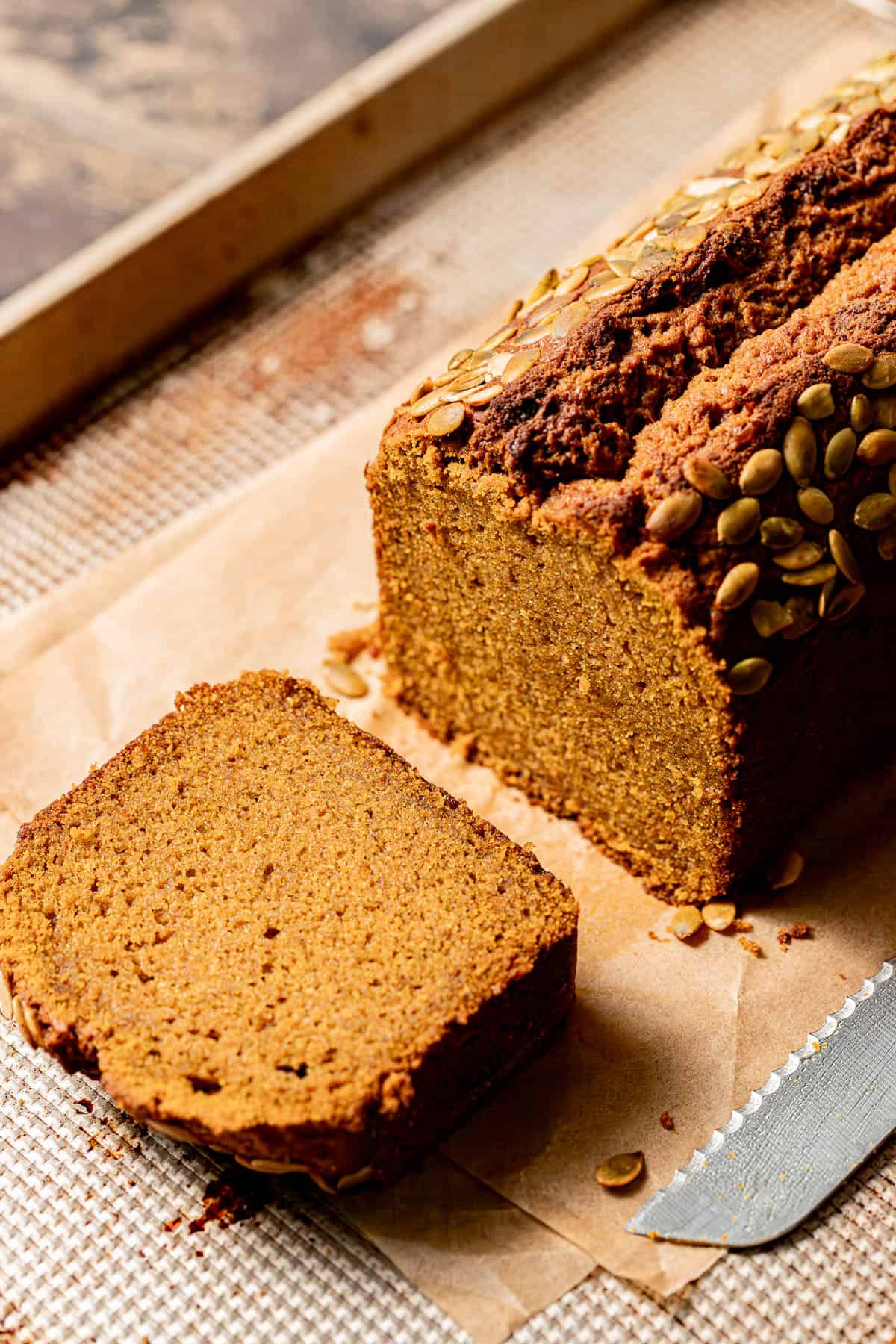 brown butter pumpkin bread loaf with one slice laying on its side.