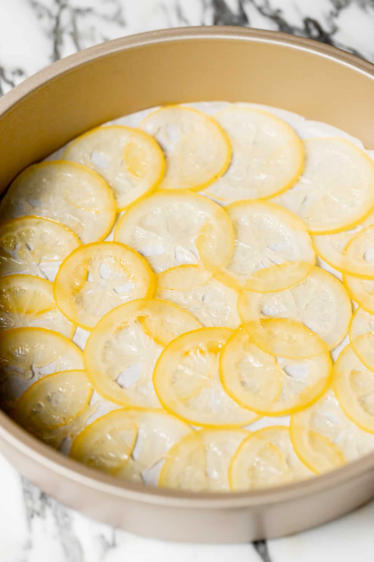 candied lemon slices arranged in cake pan.