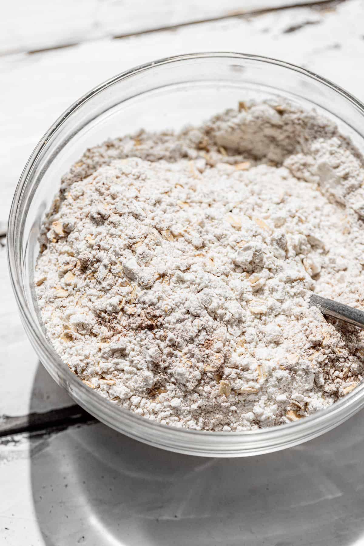 dry ingredients in a glass bowl on a white surface.