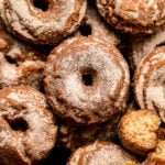 old fashioned apple cider donuts piled on baking sheet.