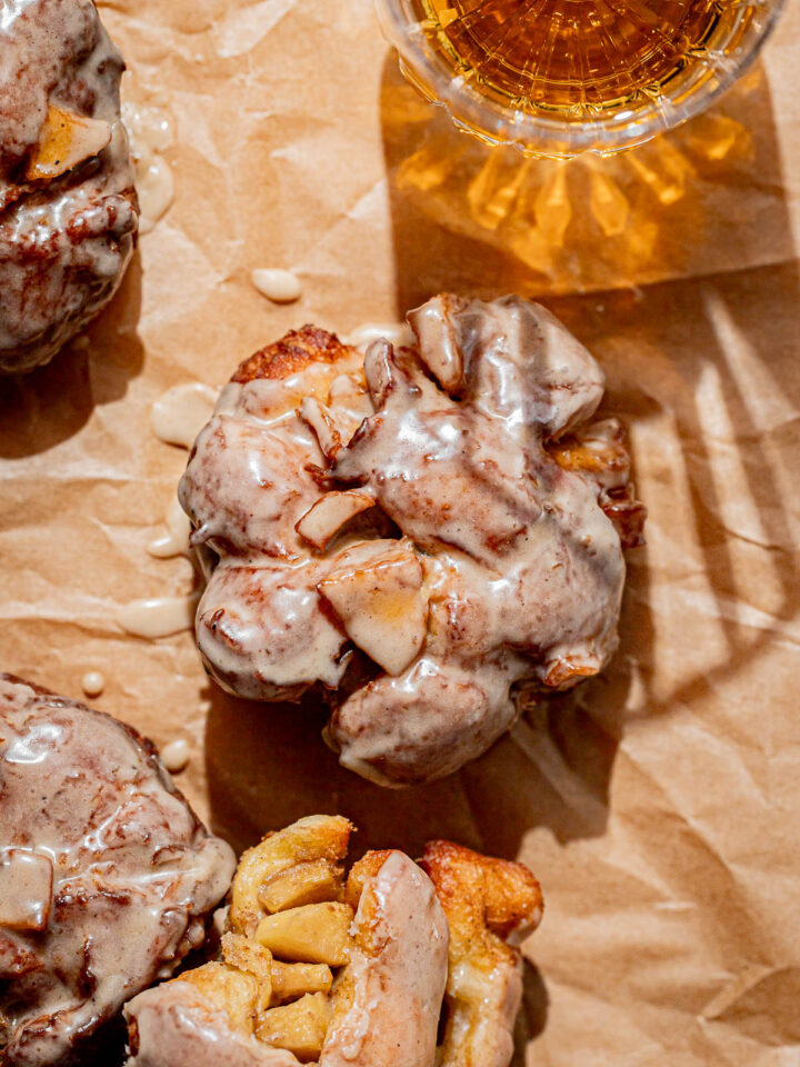 apple fritters on parchment paper.