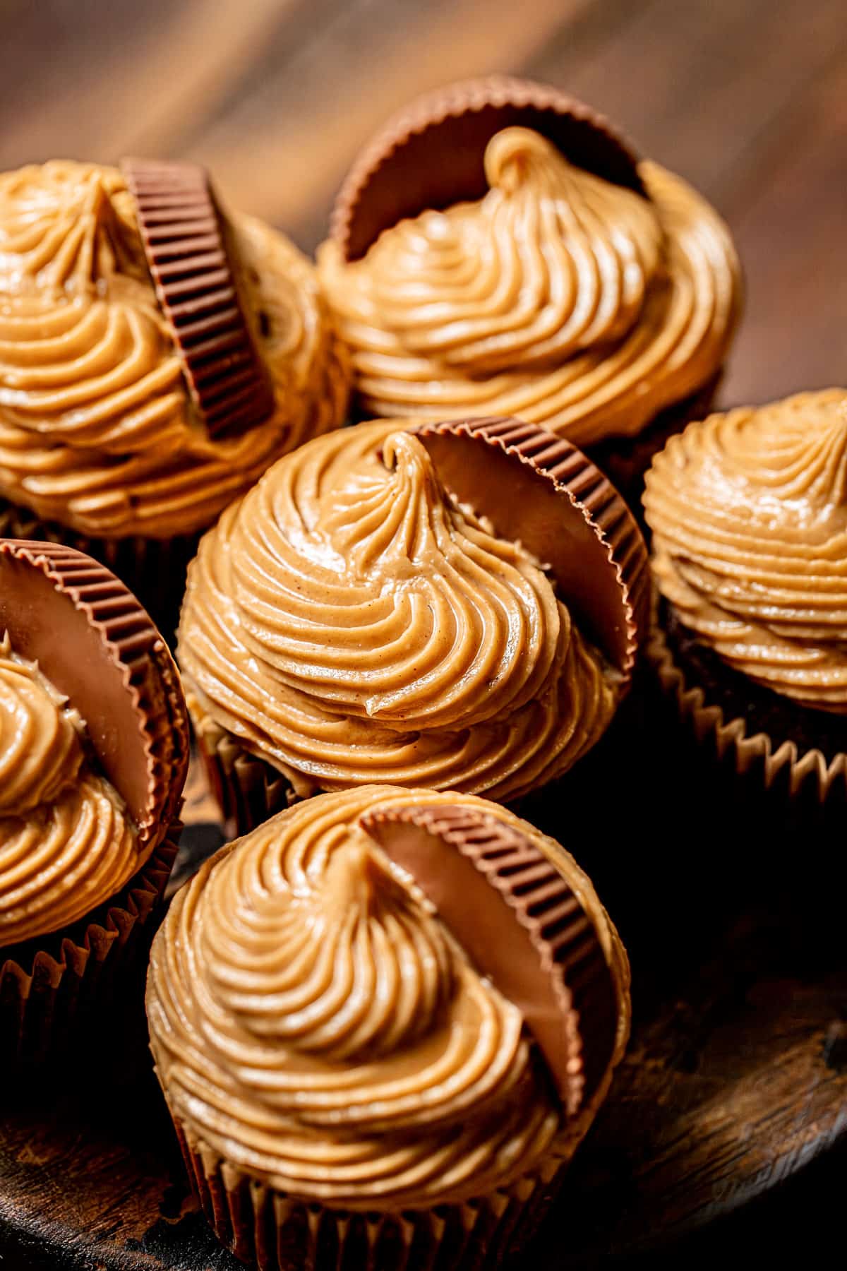 chocolate peanut butter cup cupcakes on wooden surface.