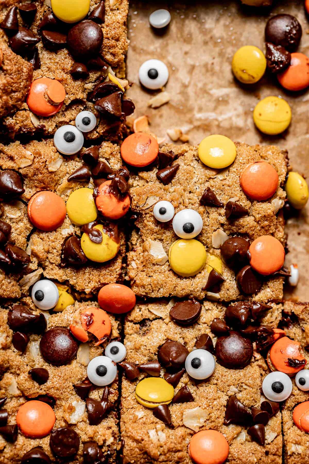 close up of monster cookie bars on parchment paper.