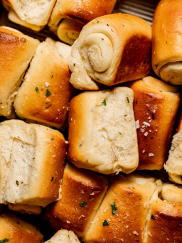 garlic herb Parker house rolls piled in baking dish.