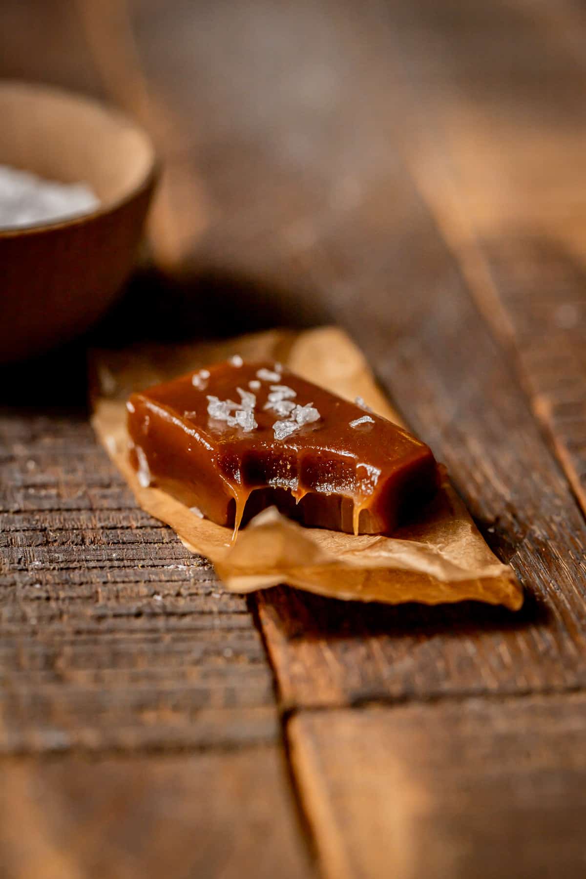 salted whisky caramel on parchment paper with bite taken out.
