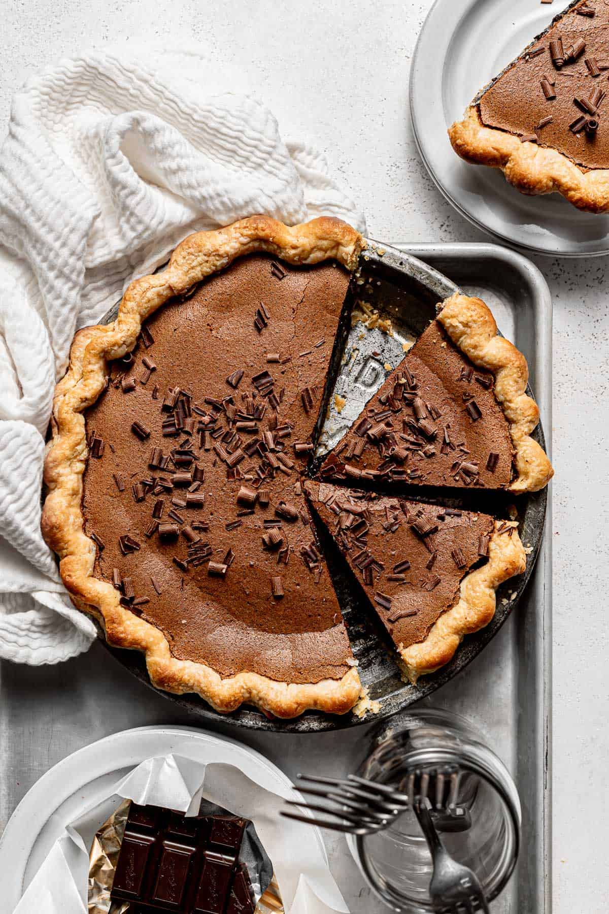 chocolate chess pie in pie plate with two pieces sliced.