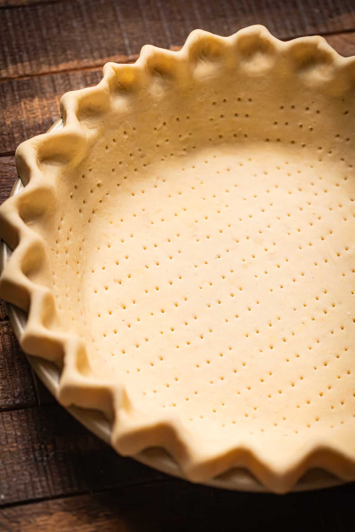 pie crust in pie pan docked and crimped.