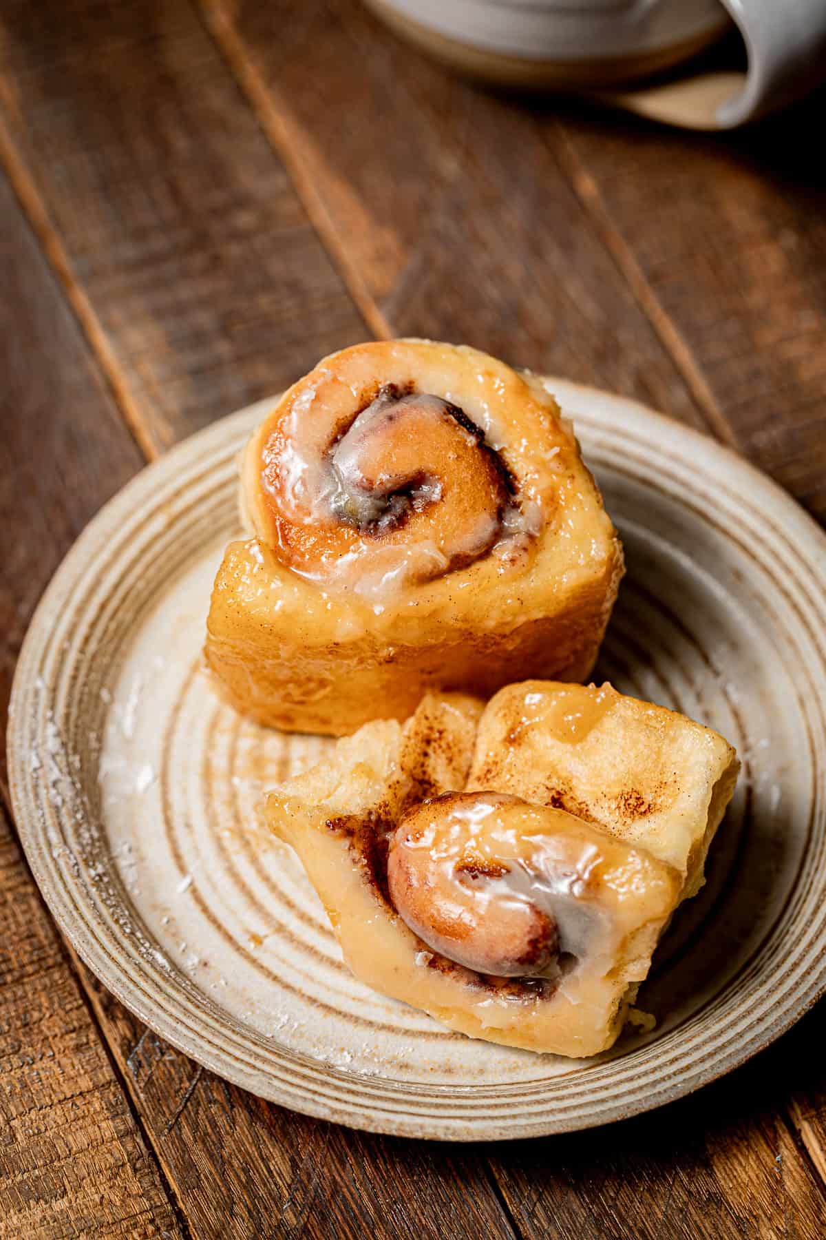 mini cinnamon roll with heavy cream on plate.