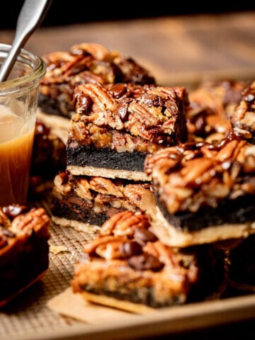 pecan pie brownies stacked on baking sheet.