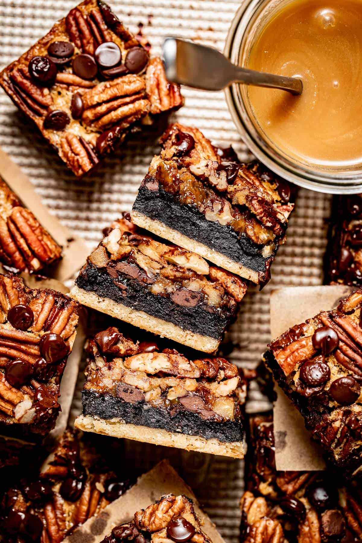 close up of pecan pie brownies on their side with more brownies around them on a baking sheet.