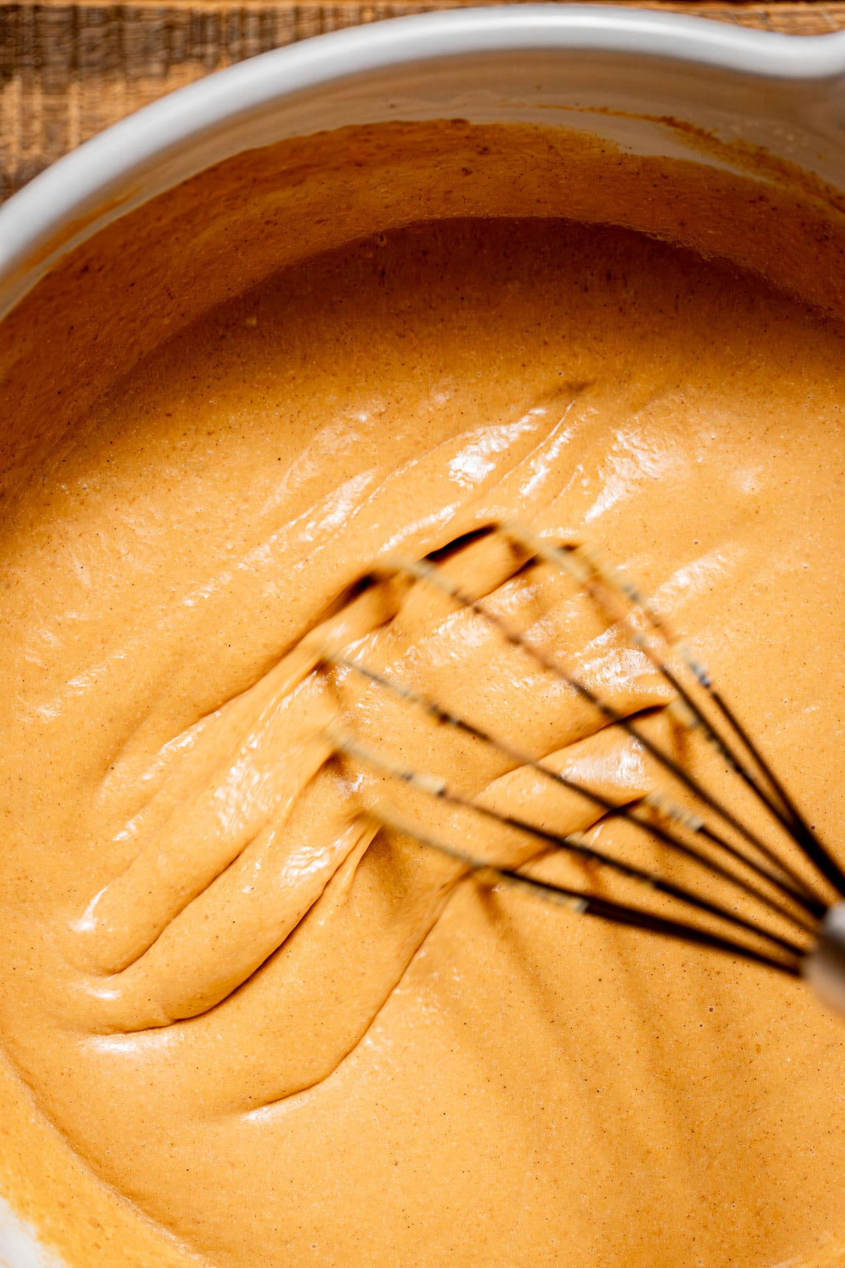 pumpkin pie filling in bowl with whisk.