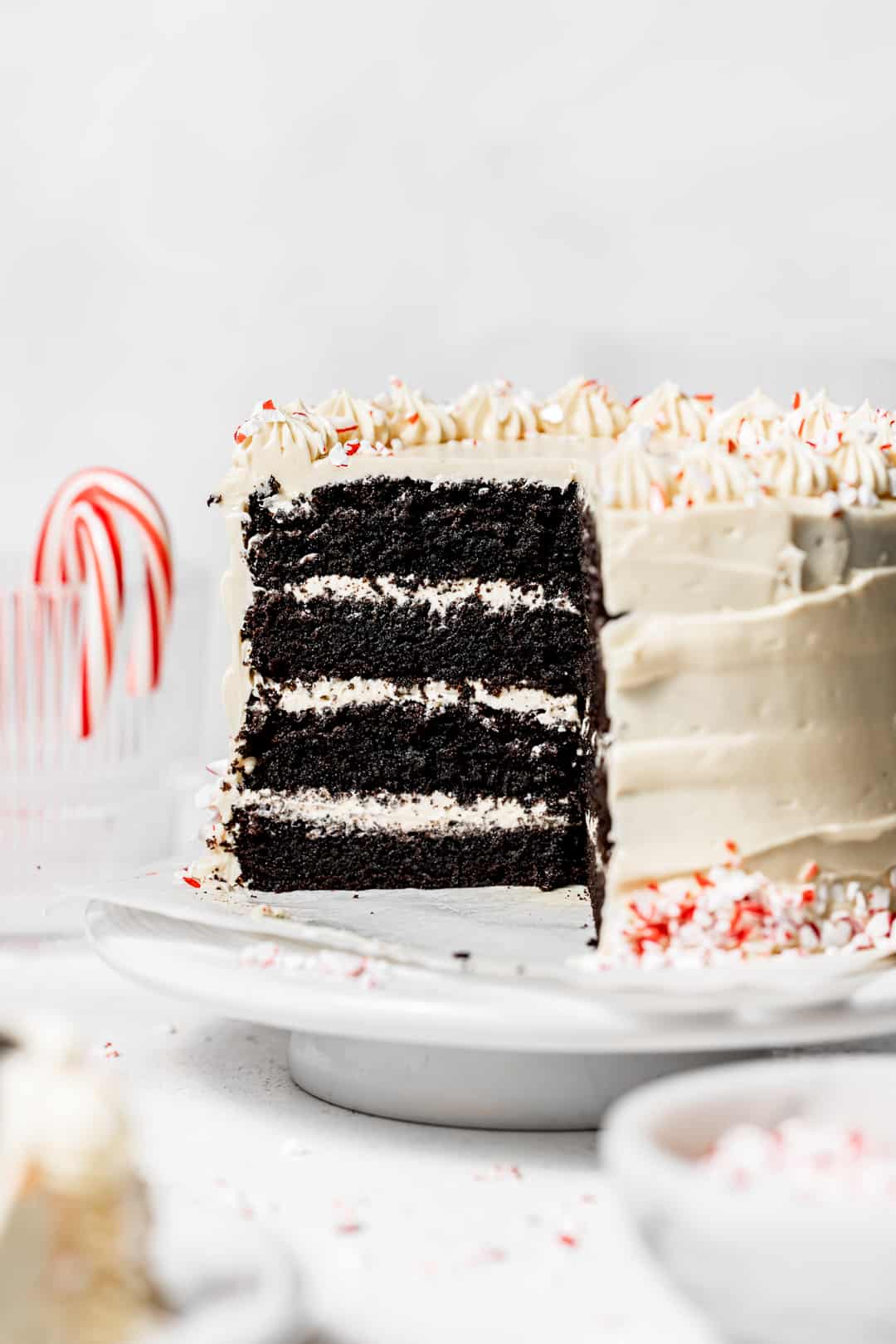 chocolate peppermint cake on white cake stand with slice taken out showing layers.