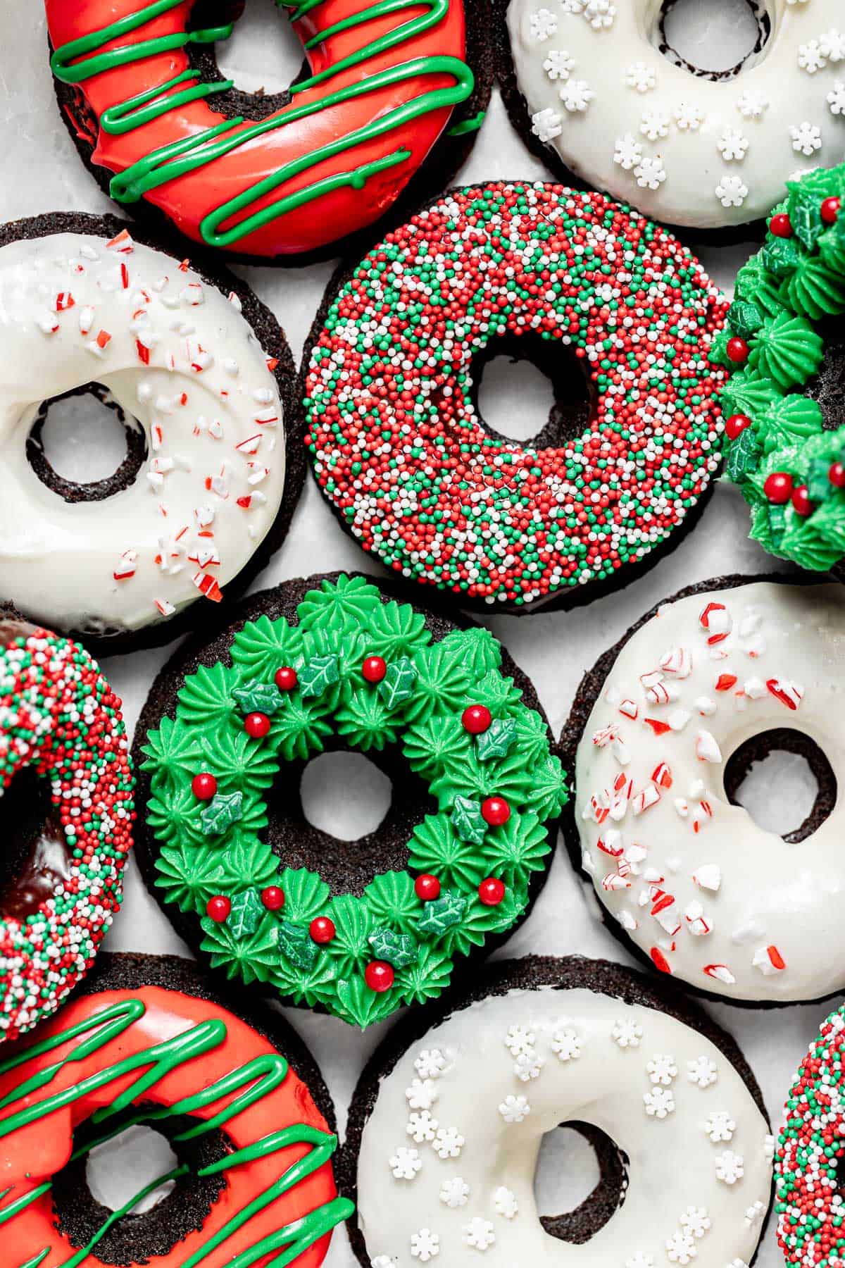 decorated christmas donuts on parchment paper.