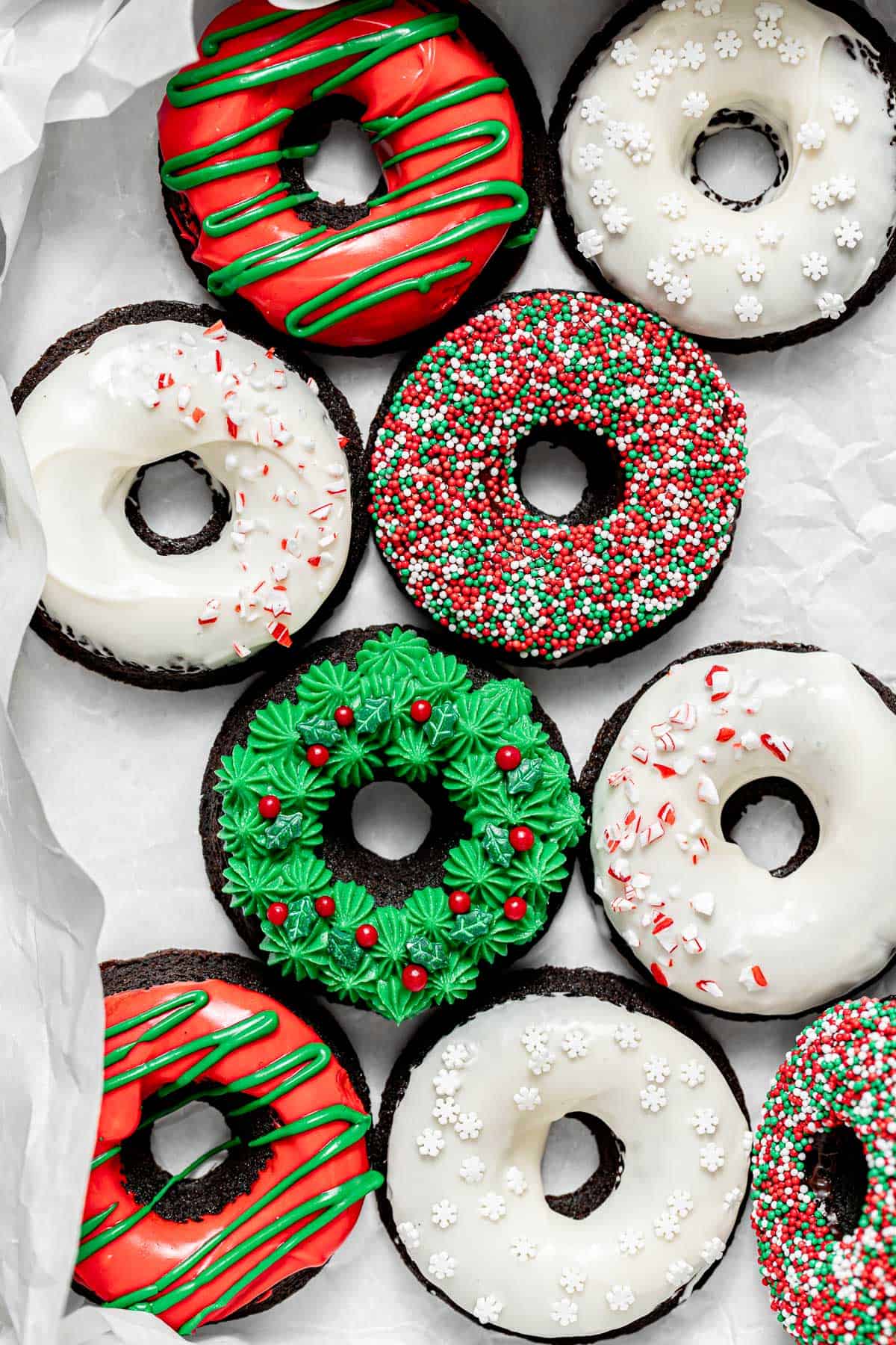 decorated donuts lined up on parchment paper.