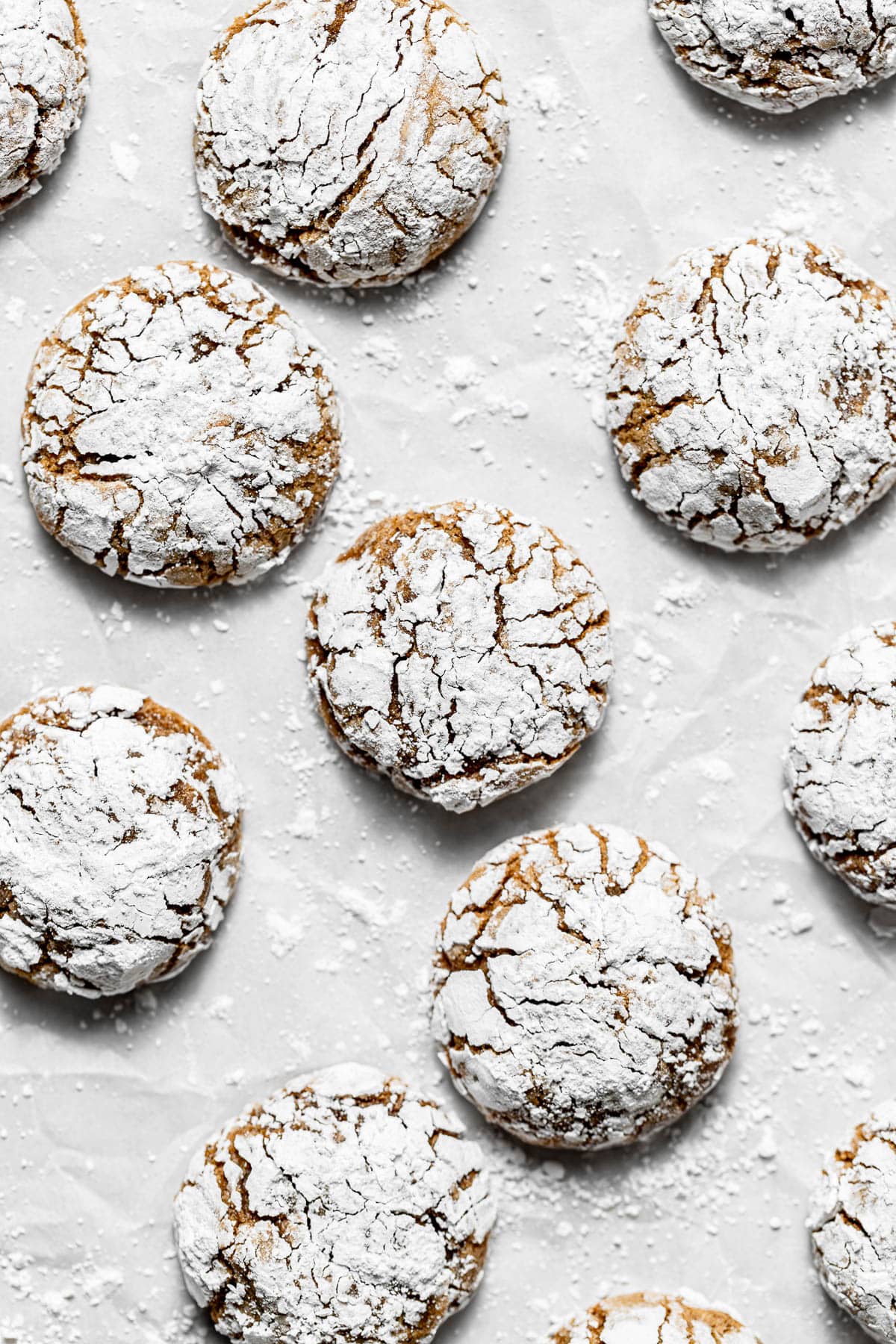 ginger molasses crinkle cookies on parchment covered baking sheet.