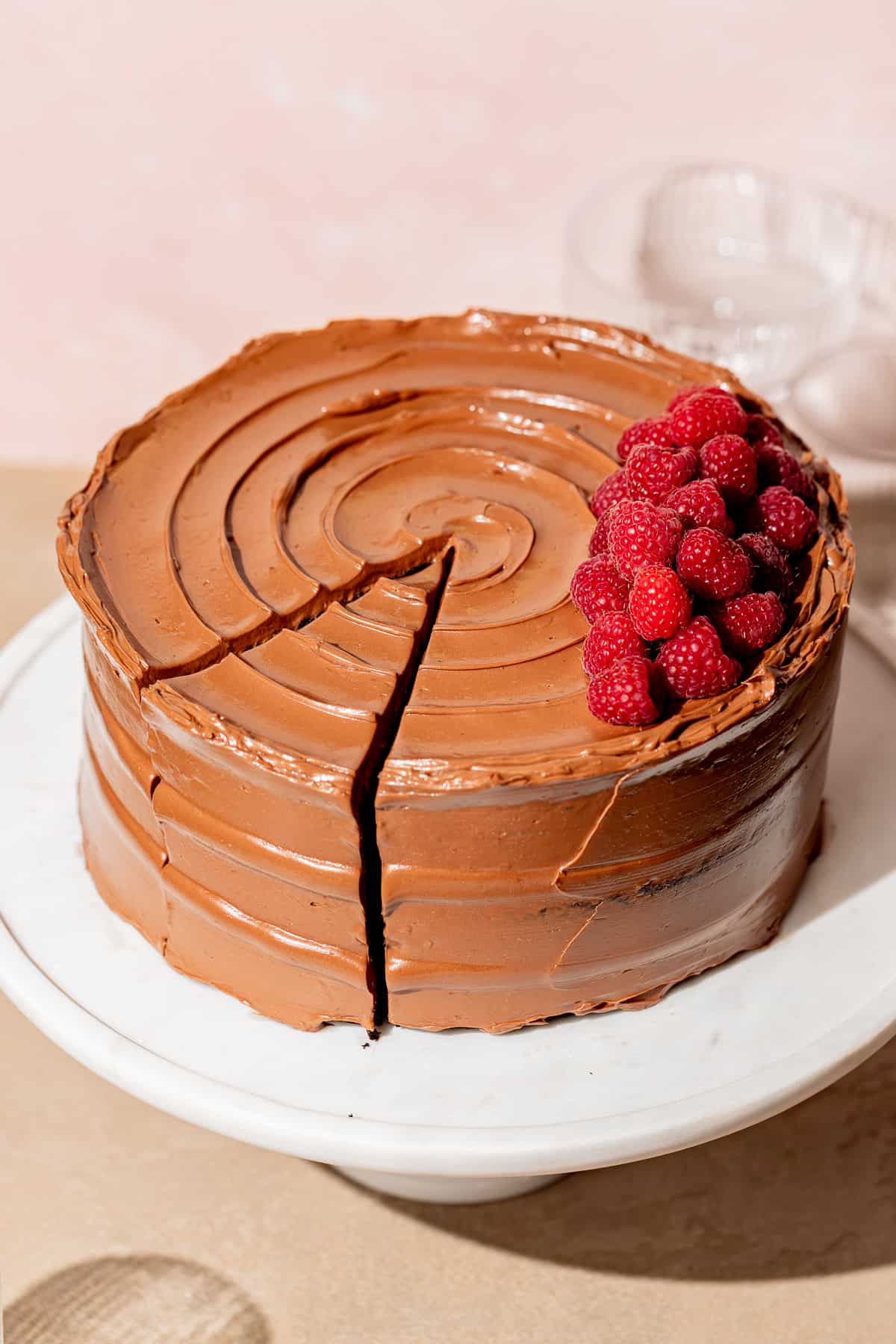chocolate raspberry cake on white marble cake stand.