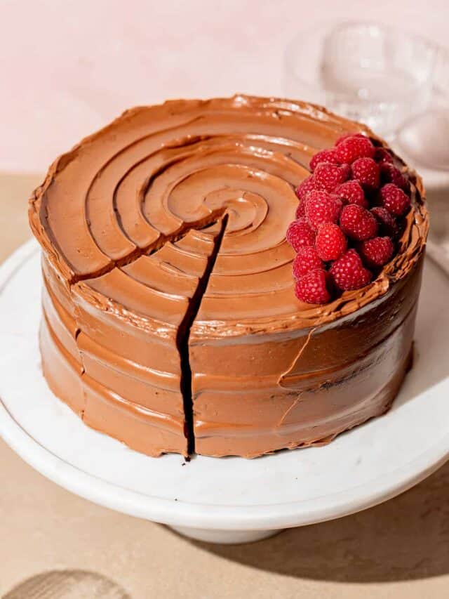 chocolate raspberry cake on white marble cake stand.