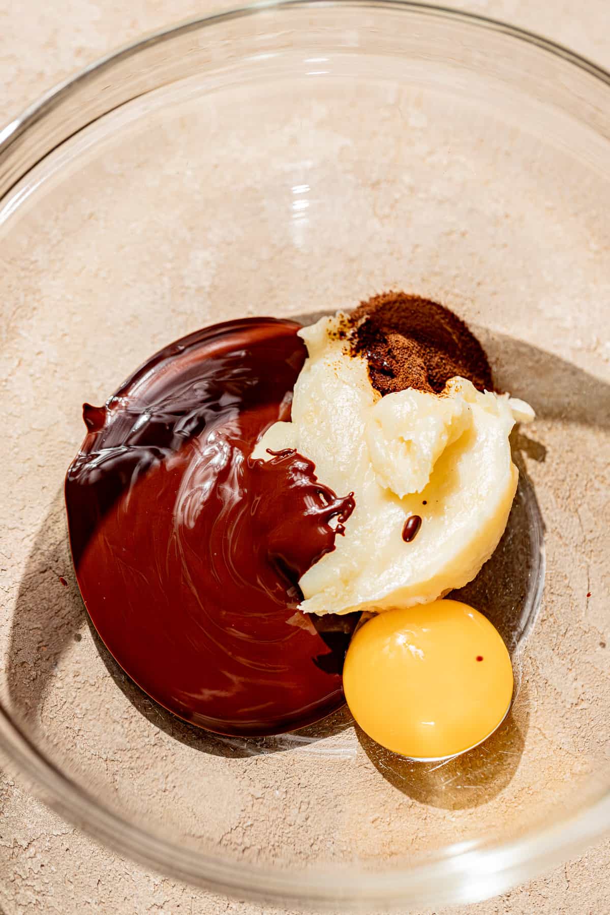 melted chocolate, egg yolk, and souffle base in bowl.