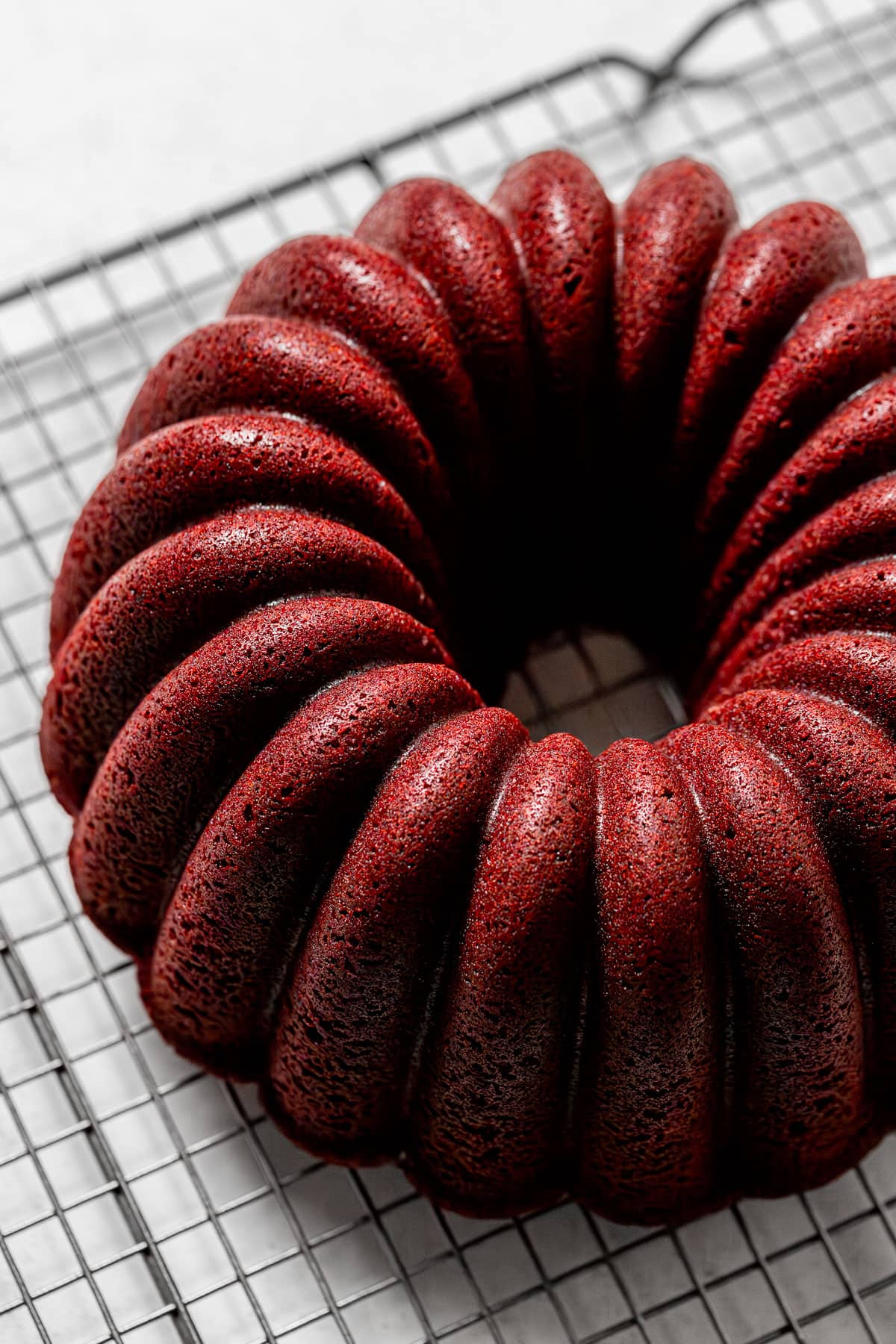 baked red velvet bundt cake on wire rack.