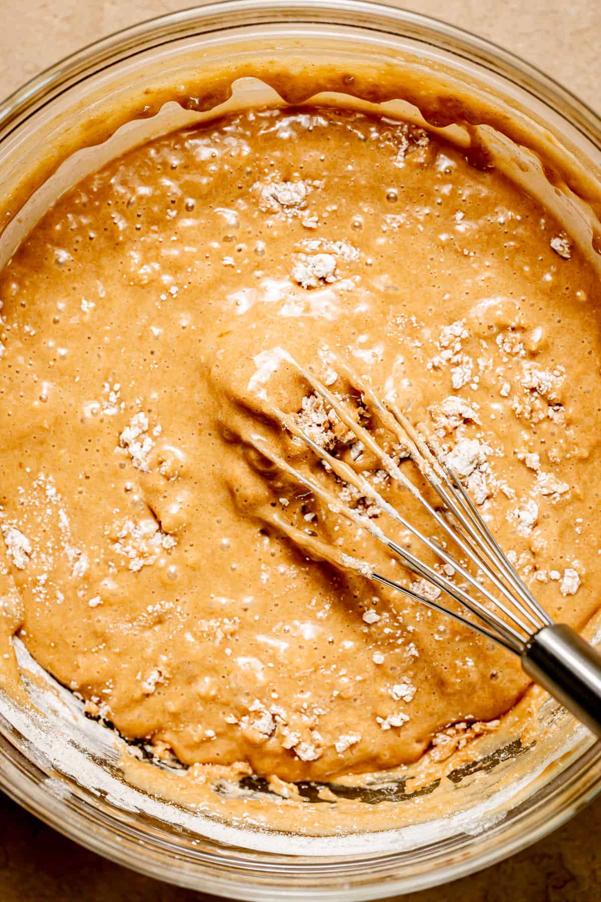 dry ingredients mixed into cake batter in bowl.