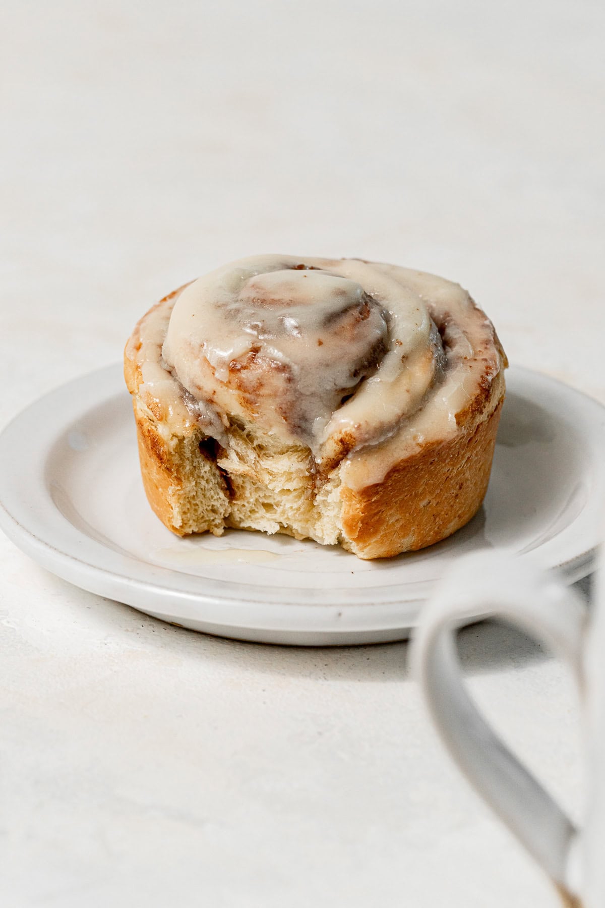 cinnamon roll with bite taken out on plate.