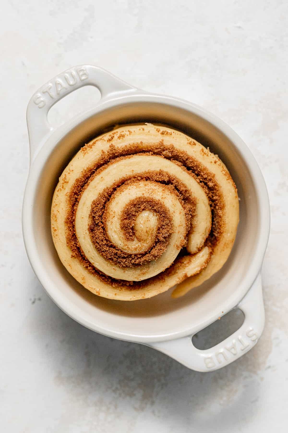 unbaked cinnamon roll in mini cocotte. 