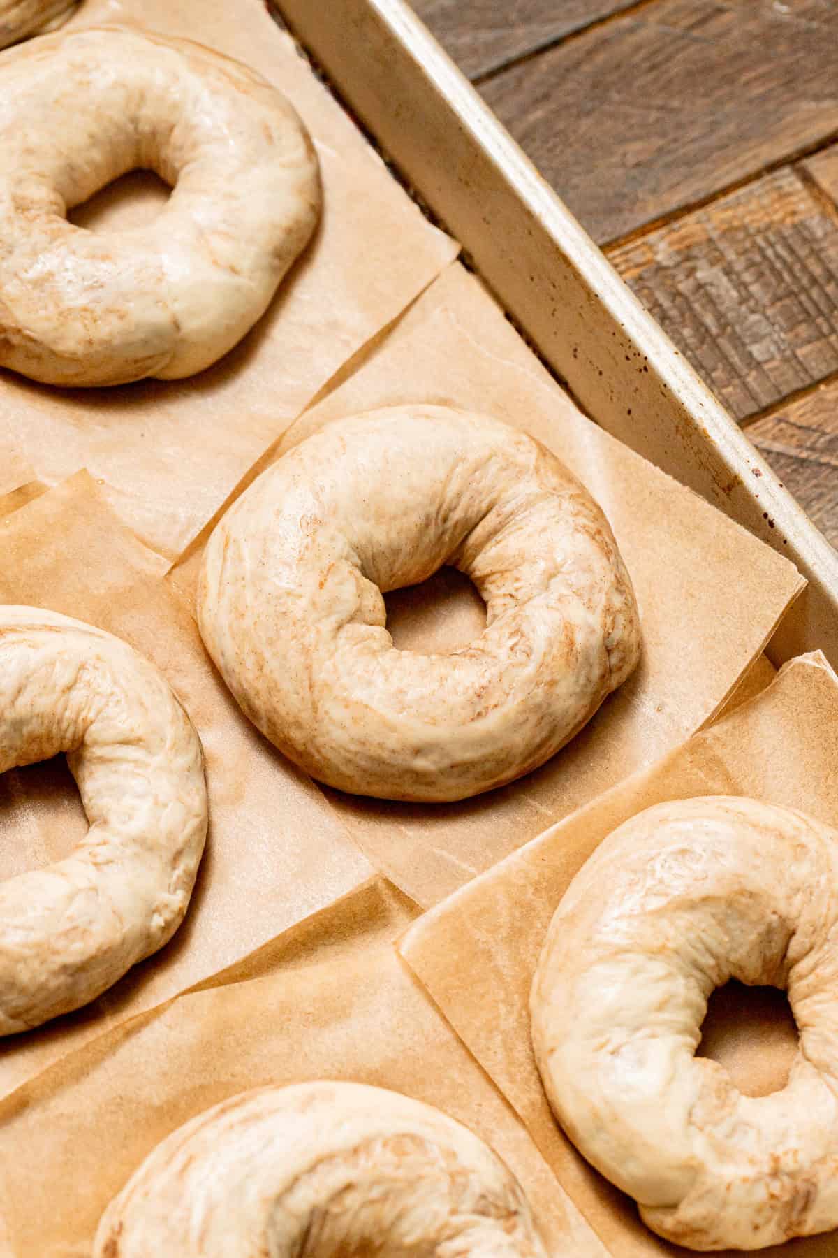 shaped bagels on baking sheet.