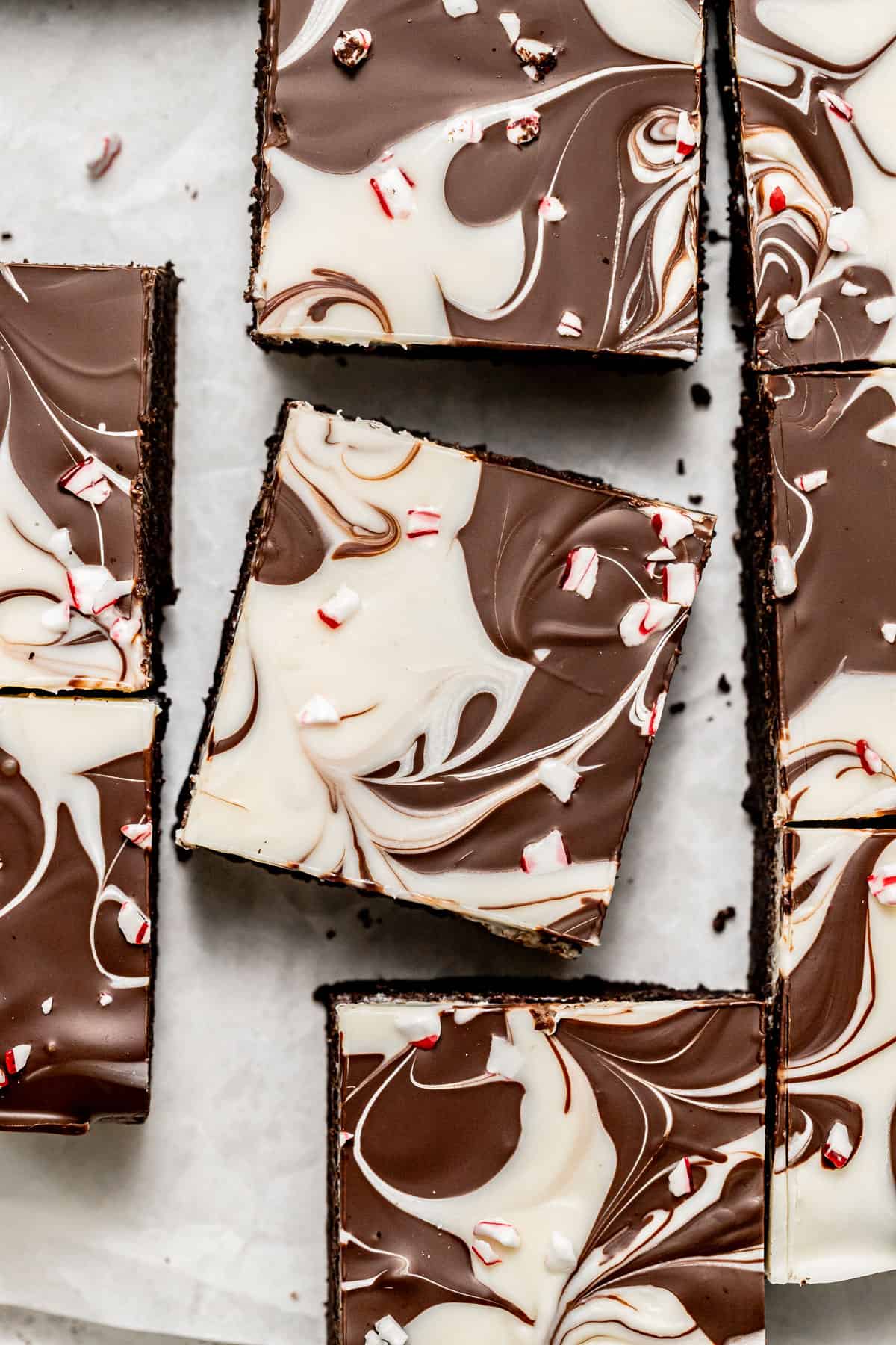 peppermint bark brownies on parchment paper.