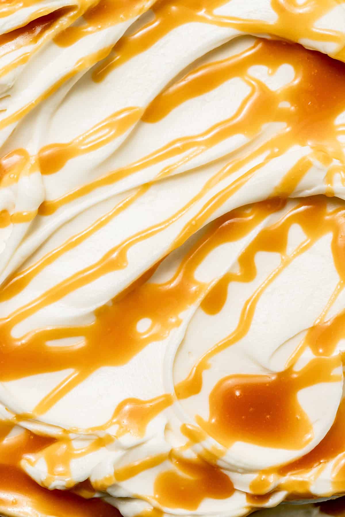 close up of cream cheese frosting and caramel sauce drizzle. 